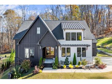 Charming two-story home with a combination of white and black siding and a well-manicured lawn at 4835 Fields Bridge Rd, Cumming, GA 30028