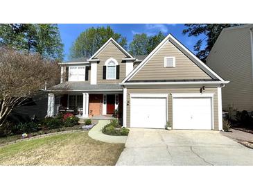 Charming two-story home with a two-car garage, manicured lawn, and red front door at 9030 Brockham Way, Johns Creek, GA 30022