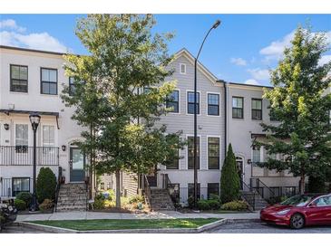Charming townhome featuring a well-manicured lawn, brick accents, and classic architectural details at 2026 Manchester Ne St, Atlanta, GA 30324