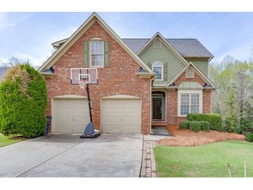 Charming two-story brick home with a well-manicured lawn and a basketball hoop over the two-car garage at 3743 Southland Dr, Buford, GA 30519