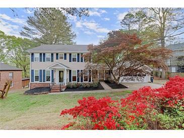 Charming two-story home with manicured lawn, colorful landscaping, and blue shutters at 1196 Oak Sw Rd, Lilburn, GA 30047