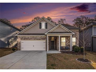 Charming single Gathering home featuring a brick and siding exterior, manicured lawn, and two-car garage at 345 Caledonia Ct, Peachtree City, GA 30269