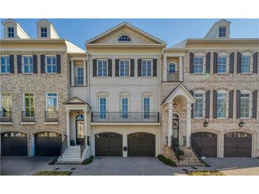 Charming brick townhome with symmetrical design, multiple windows, and integrated garages at 9044 Riverbend Manor, Alpharetta, GA 30022