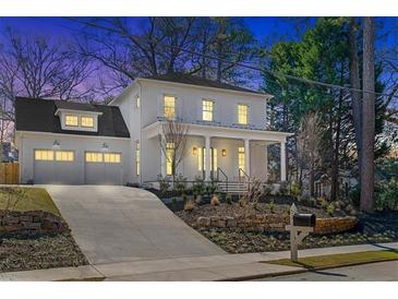 Elegant two-story white home with a covered porch, beautiful landscaping, and a spacious two-car garage at 52 25Th Nw St, Atlanta, GA 30309