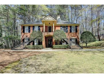 Charming brick home featuring dual staircases and a welcoming, covered entryway with a columned portico at 30 Plantation Ne Dr # B, Atlanta, GA 30324
