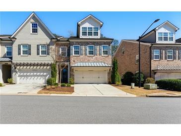 Charming brick-front townhome with a two-car garage and well-manicured landscaping at 3172 Havencroft Ne Dr, Roswell, GA 30075