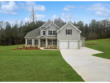 Charming gray two-story home with a well-manicured lawn and a two-car garage at 3292 Lions Ruby Ln, Atlanta, GA 30349