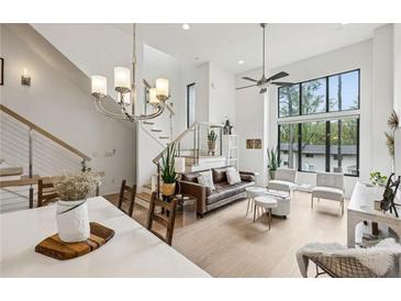 Open living space with a modern chandelier, staircase, and large windows for natural light at 728 Oakview Rd, Decatur, GA 30030