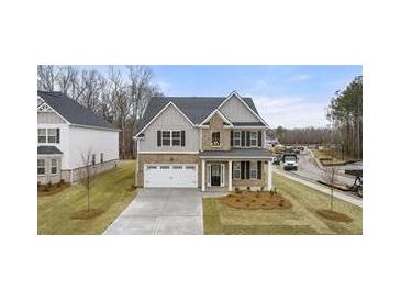 Beautiful two-story home featuring a two-car garage, a stone-accented entrance, and a well-manicured lawn at 13917 Homer Lane, Covington, GA 30014