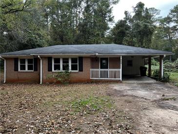 Charming brick ranch-style home with a covered carport and mature trees at 2369 Christian Cir, Covington, GA 30016