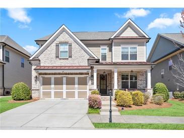 Charming two-story home with a brick and siding exterior, a well-manicured lawn, and an attached two-car garage at 11395 Crestview Ter, Johns Creek, GA 30024
