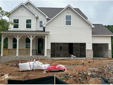 Two-story white home featuring a covered porch and unfinished two-car garage at 363 Riverwood Pass, Dallas, GA 30157