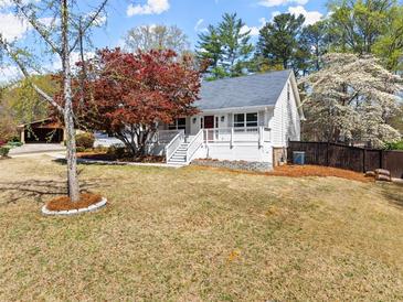 Charming two-story home with white siding, a red door, and a inviting front porch at 385 Jayne Ellen Way, Alpharetta, GA 30009