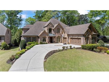 Stately brick and stone home with a circular driveway and beautifully landscaped front yard at 931 Fairfield Dr, Marietta, GA 30068