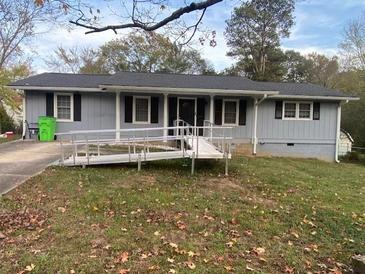 Ranch home with gray exterior, dark roof, and convenient ramp to the front door at 4691 Bo Hendrick Dr, Austell, GA 30106