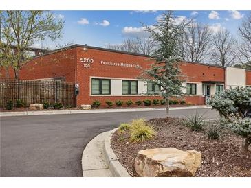 Brick building with well-maintained landscaping and visible address numbers at 5200 Peachtree Rd # 1111, Atlanta, GA 30341