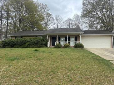 Charming single-story home featuring a well-maintained lawn and an attached two-car garage at 1430 Country Lane Ne Dr, Conyers, GA 30012