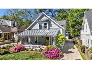 Charming home with a welcoming front porch, beautiful azaleas, and a well-manicured lawn at 323 Fayetteville Rd, Decatur, GA 30030