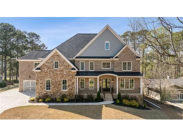 Beautiful brick and stone home featuring a spacious front yard and a welcoming front porch at 3669 High Green Dr, Marietta, GA 30068