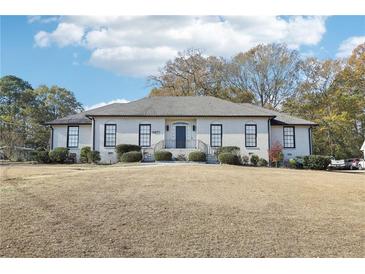 Stunning one story home featuring a symmetrical design, manicured landscaping, and a welcoming entrance at 8671 Lake Forrest Dr, Douglasville, GA 30134