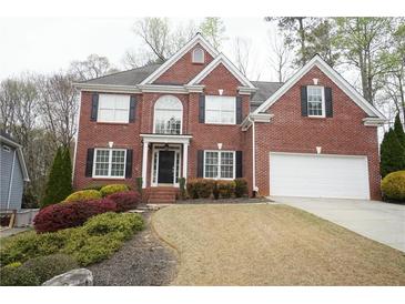 Charming two-story brick home with well-manicured landscaping, and an attached two car garage at 1191 Crofton Landing, Suwanee, GA 30024