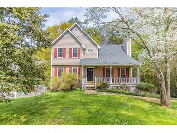 Charming two-story home with red shutters and a cozy front porch surrounded by lush greenery at 116 Shefield Pl, Douglasville, GA 30134