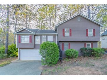 Charming split-level home with gray siding, red shutters, and a well-maintained front yard at 3094 Calumet Nw Cir, Kennesaw, GA 30152