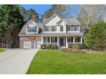 Charming two-story home with a well-manicured lawn, a two-car garage, and a welcoming front porch at 3823 Briarstone Cv, Snellville, GA 30039