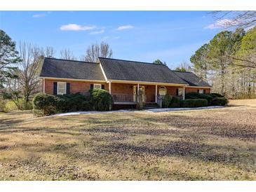 Ranch-style brick home with a dark roof, manicured shrubs, and a welcoming front porch at 105 Ruff Harris Dr, Dallas, GA 30157