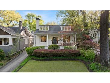 Charming two-story home with a landscaped front yard, covered entry, and mature trees at 1450 N Morningside Ne Dr, Atlanta, GA 30306
