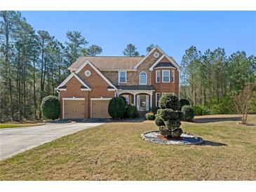 Charming brick home with a well-maintained lawn and two-car garage situated amongst lush trees at 1920 Barrington Dr, Jonesboro, GA 30236