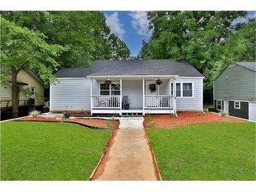 Charming single story home with a cozy front porch, green lawn and a walkway to the front door at 1094 Regent Sw St, Atlanta, GA 30310