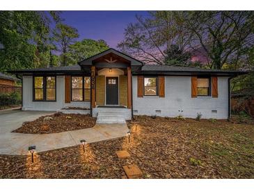 Charming home with a manicured lawn, brick facade, and stylish wood accents at 1934 Pinedale Pl, Decatur, GA 30032