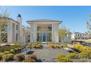A modern two-story home has a blue front door and a garden in front with bushes and benches at 260 Guild Ln, Fayetteville, GA 30214