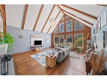 Bright living room boasting vaulted ceilings, wood beams, large windows, hardwood floors and modern decor at 53 Weatherstone Pkwy, Marietta, GA 30068