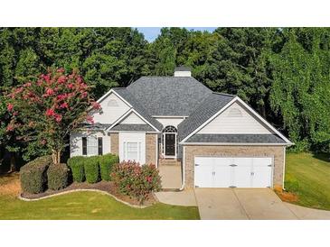 Charming single-Gathering home featuring a brick facade and a manicured lawn, complemented by mature trees at 5915 Windsorcreek Dr, Douglasville, GA 30135