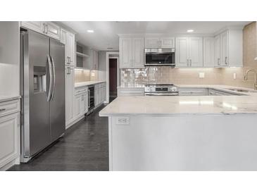 Modern kitchen features stainless steel appliances, a wine cooler, white cabinetry, and marble countertops at 2769 Peachtree Ne Rd # 10, Atlanta, GA 30305