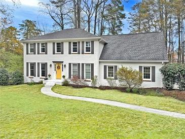 Charming two-story white brick home with black shutters and a well-manicured front lawn at 2480 Roxburgh Dr, Roswell, GA 30076