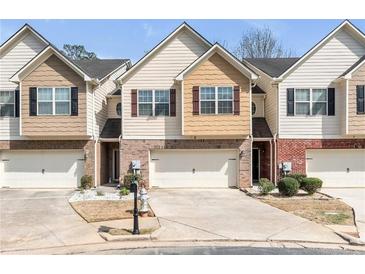 Charming townhome showcasing brick accents, a one-car garage, and a meticulously maintained front yard at 5 Burns View Ct, Lawrenceville, GA 30044