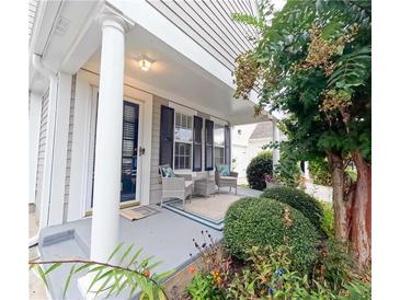 Inviting front porch with neutral chairs, a rug, and a view of the landscaped front yard at 1488 Cottage Way #32, Marietta, GA 30066