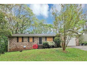 Charming brick home with a well-maintained front yard and a lovely red flowering bush at 6884 Stephens Dr, Rex, GA 30273