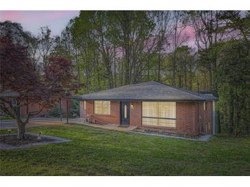 Charming brick home featuring a well-manicured lawn and mature trees, creating a peaceful and inviting curb appeal at 2875 Oldknow Nw Dr, Atlanta, GA 30318