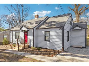 Charming home featuring gray siding, black trim, a red front door, and fresh landscaping at 1591 Athens Sw Ave, Atlanta, GA 30310