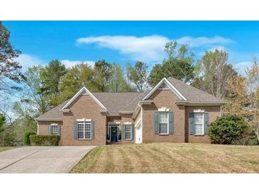 Charming single-story brick home featuring manicured landscaping and a well-maintained front yard with mature trees at 4162 Crowder Nw Dr, Kennesaw, GA 30152