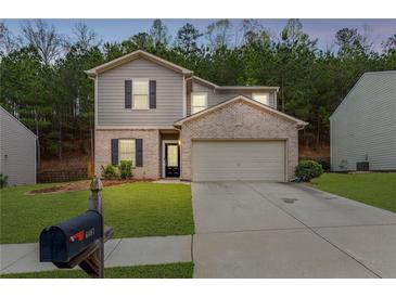 Charming two-story home featuring a brick facade, a well-manicured lawn, and an attached two-car garage at 6407 Barker Station Walk, Sugar Hill, GA 30518
