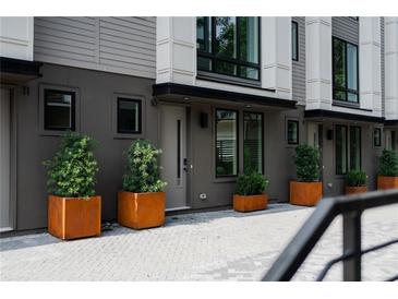 Modern townhome exterior featuring a row of units with gray siding and decorative landscaping at 1160 Ormewood Ave # 13, Atlanta, GA 30316