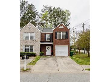 Charming two-story brick home featuring an attached garage and a beautifully manicured front yard at 1501 Eastern Sunrise Ln, Decatur, GA 30034