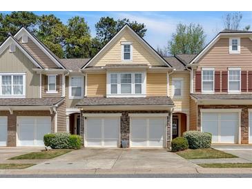 Charming townhome featuring a stone facade, two-car garage, and inviting curb appeal at 1929 Lake Heights Nw Cir # 2, Kennesaw, GA 30152