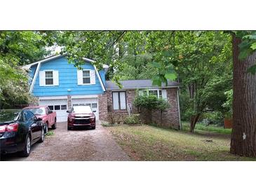Charming home with brick facade, attached two-car garage, and a cozy, inviting front yard at 1207 Denison Dr, Clarkston, GA 30021