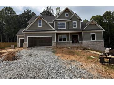 Two-story home featuring an attached two-car garage, and a combination of stone and siding exterior at 1081 Holly Dr, Loganville, GA 30052